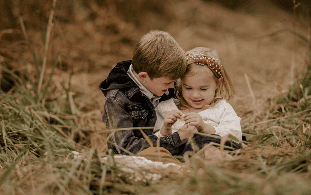 Two children laughing in field